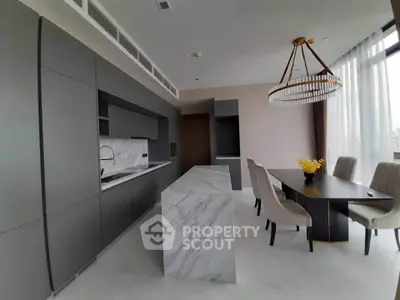 Luxurious modern kitchen with marble island and elegant dining area in high-rise apartment.