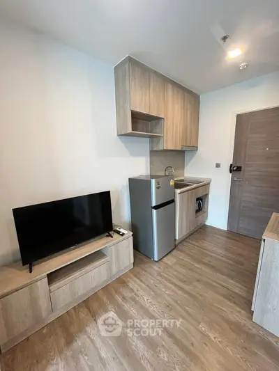 Modern compact living room with kitchenette and wooden flooring