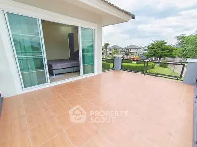 Spacious balcony with sliding glass doors and scenic view of residential area.