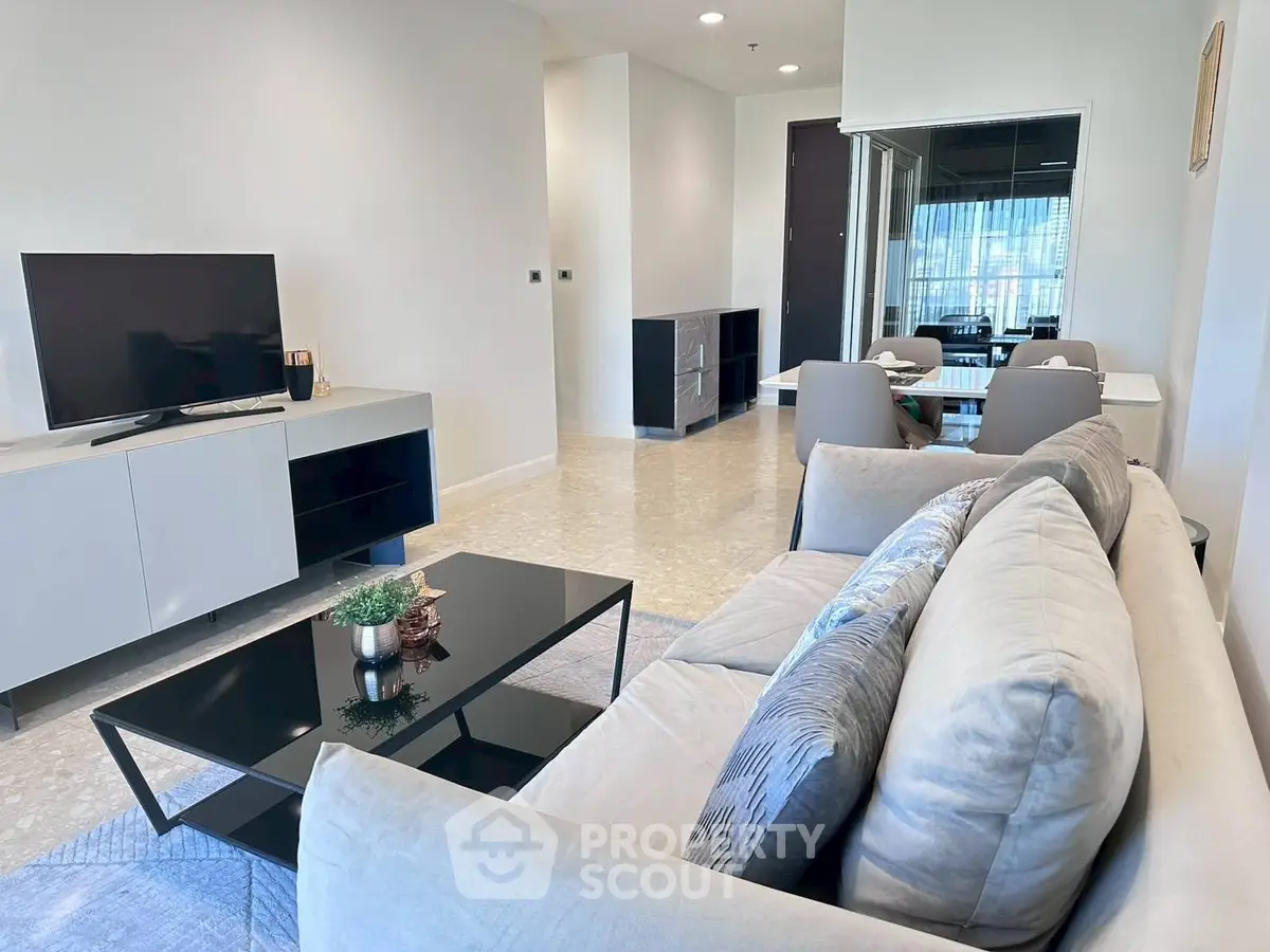 Modern living room with sleek furniture and large TV, perfect for relaxation and entertainment.