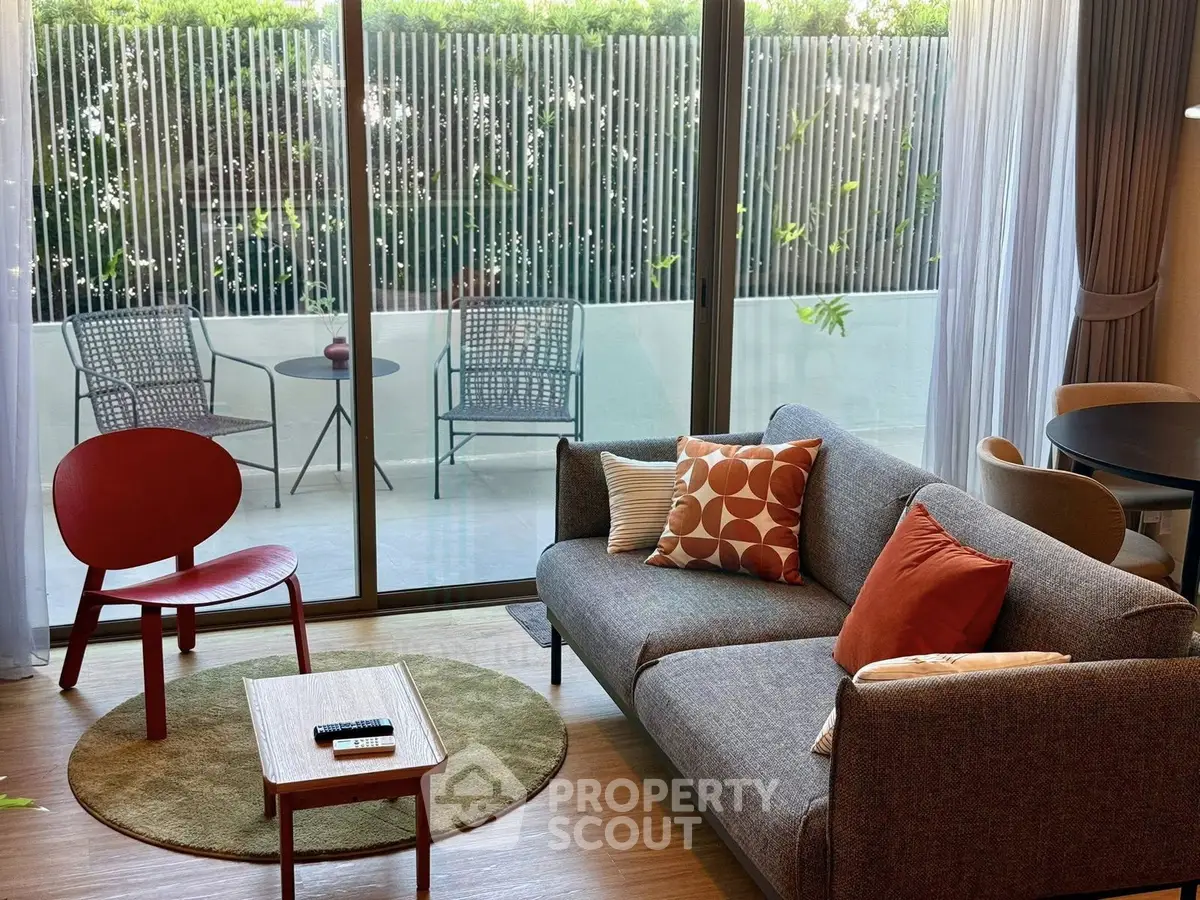 Modern living room with stylish furniture and large balcony view