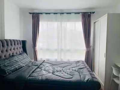 Cozy bedroom with elegant bed and large window offering natural light
