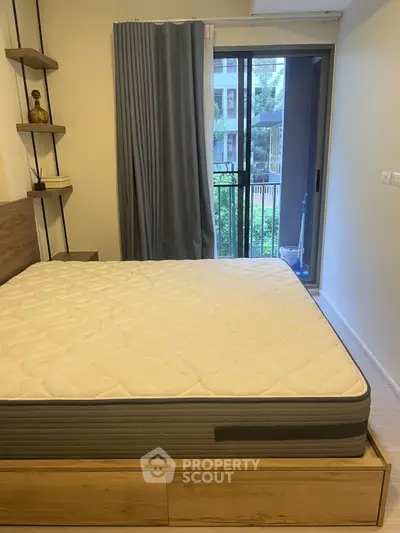 Modern bedroom with large window and garden view, featuring a stylish bed and elegant decor.
