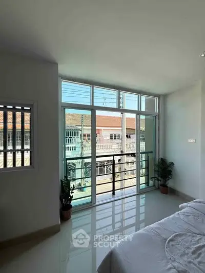 Bright bedroom with large windows and balcony view in modern home