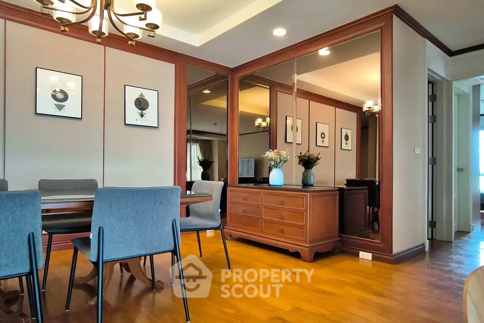 Elegant dining room with wooden floors, stylish chandelier, and modern decor.