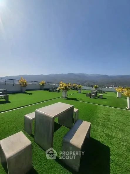 Stunning rooftop terrace with modern seating and panoramic mountain views, perfect for relaxation and entertainment.