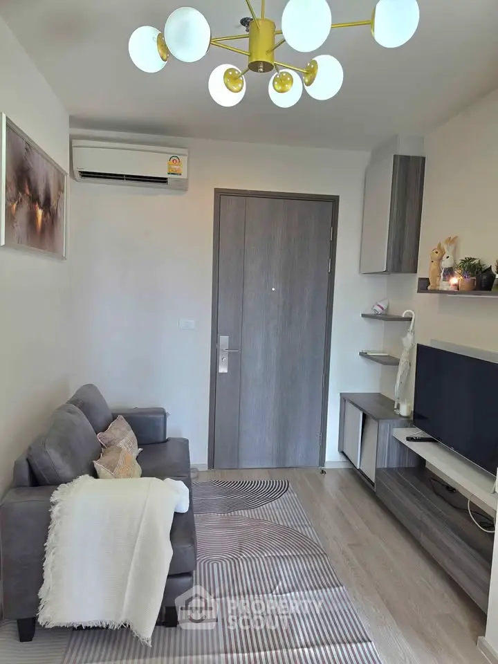 Cozy living room with modern decor and stylish lighting in a compact apartment.