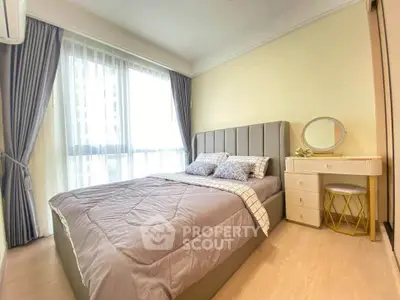 Cozy bedroom with modern decor and ample natural light in a stylish apartment.