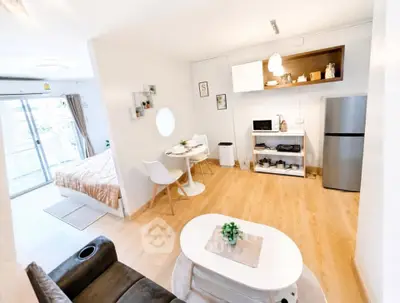 Modern open-plan living room with kitchen and dining area, featuring stylish decor and natural light.