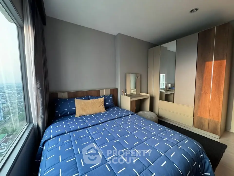 Modern bedroom with city view, featuring stylish decor and ample natural light.