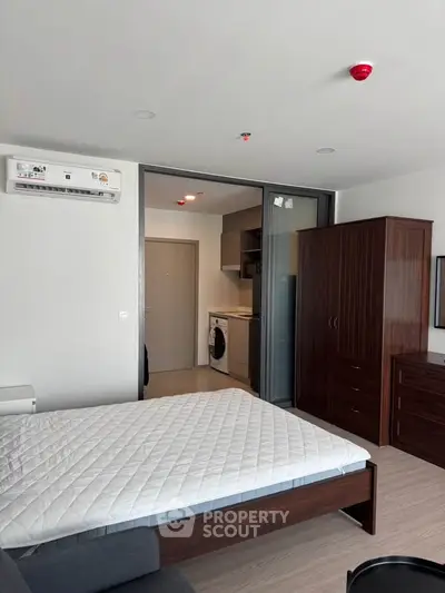Modern studio apartment with sleek furniture and in-unit washer, perfect for urban living.