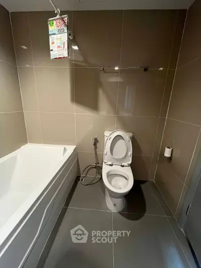Modern bathroom with sleek tile design and bathtub in contemporary apartment.