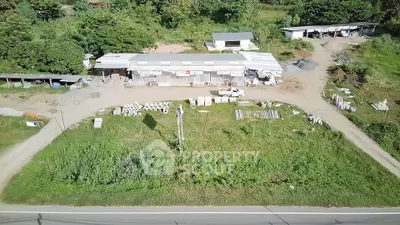 Aerial view of a rural property with industrial buildings and greenery.