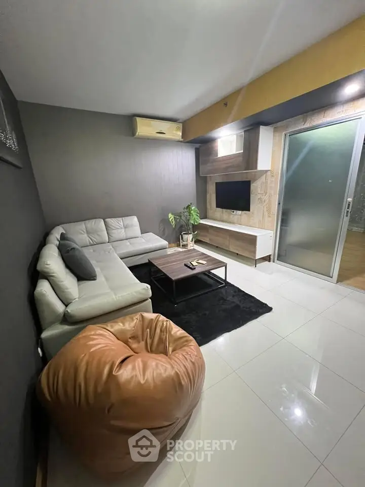 Modern living room with sleek furniture and stylish decor, featuring a cozy sofa and entertainment setup.