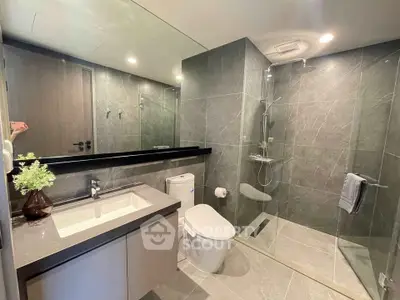 Modern bathroom with sleek design, featuring a spacious shower and elegant fixtures.