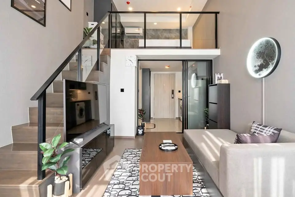 Modern loft-style living room with sleek staircase and stylish decor