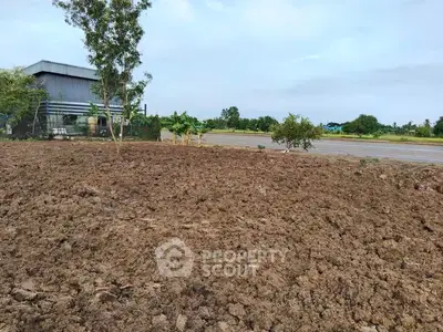 Expansive plot of land with potential for development, surrounded by greenery and open skies.