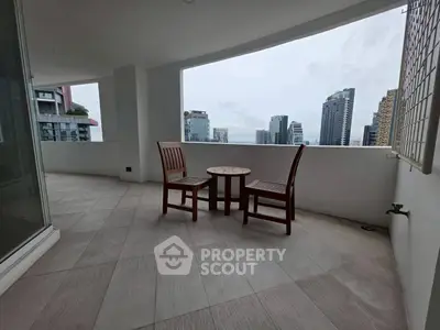 Spacious balcony with city skyline view, perfect for relaxation and entertaining.