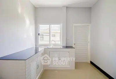 Bright minimalist kitchen with sleek countertops and ample natural light