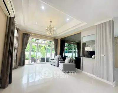 Spacious modern living room with elegant decor and large windows opening to a lush garden view.