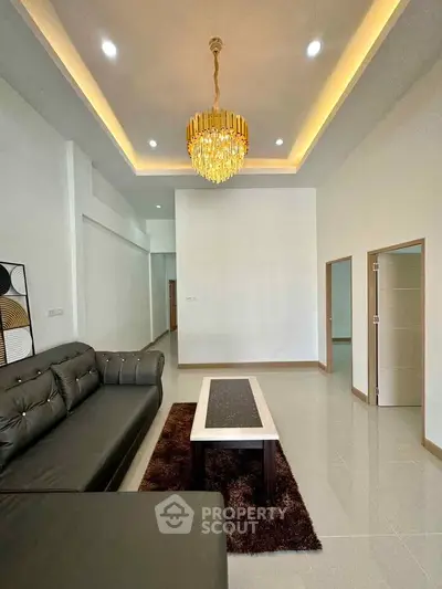 Elegant living room with modern chandelier and stylish sofa in a spacious interior.