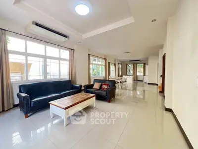 Spacious living room with elegant furniture and large windows offering natural light.