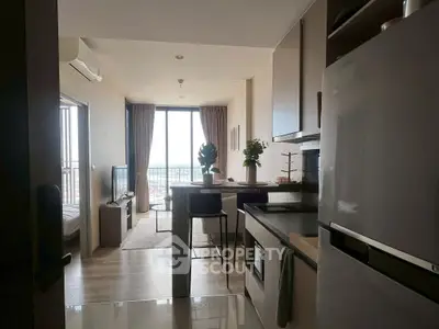 Modern open-layout apartment with kitchen and living area, featuring large windows and stylish decor.