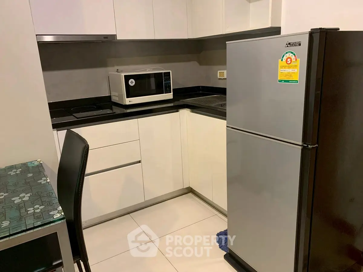 Modern kitchen with sleek appliances and minimalist design in a compact space.