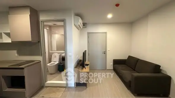 Modern apartment interior with cozy living room and adjacent bathroom