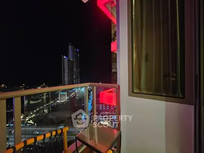 Stunning night view from a modern balcony with city lights and high-rise buildings.