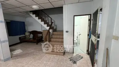 Spacious living area with staircase and adjacent bathroom in a cozy home.