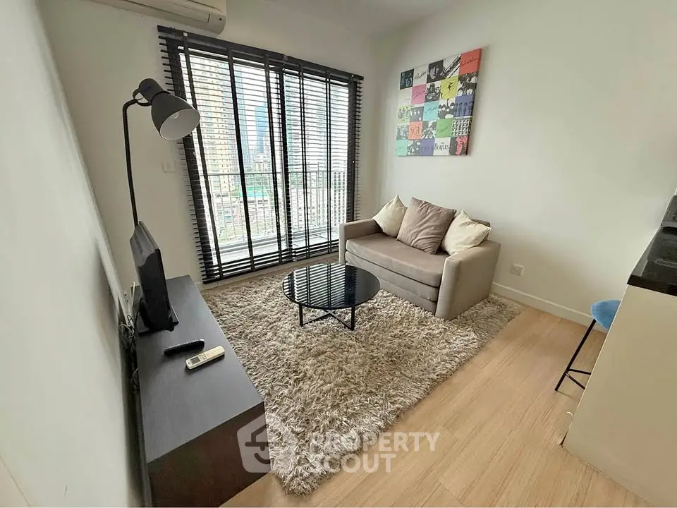 Modern living room with cozy sofa, stylish decor, and large window view.