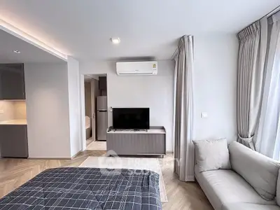 Modern bedroom with sleek design, featuring a cozy sofa, TV, and air conditioning unit.