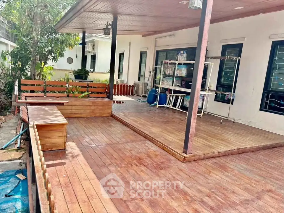 Spacious wooden deck with seating area and garden view, perfect for outdoor relaxation.