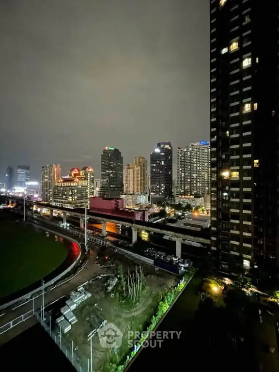 Stunning cityscape view from a high-rise building at night, showcasing vibrant urban lights and modern architecture.