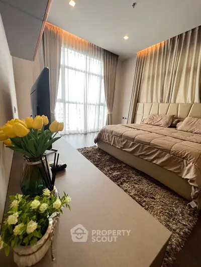 Luxurious bedroom with elegant decor and large window offering natural light.