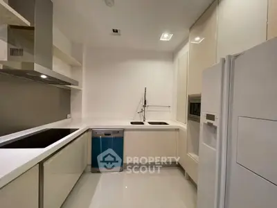 Modern kitchen with sleek appliances and minimalist design, featuring a built-in oven and spacious countertops.