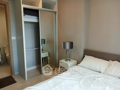 Modern bedroom with mirrored closet and stylish lamp in cozy apartment.