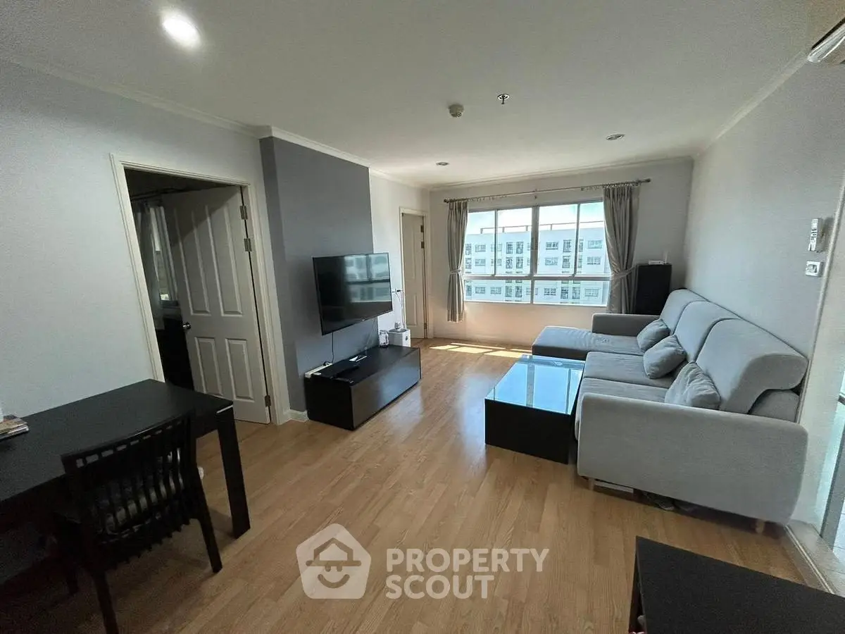 Spacious living room with modern furniture and large window view