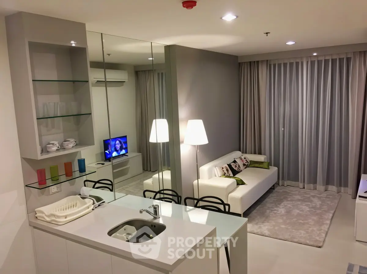 Modern living room with sleek design and open kitchen layout in a stylish apartment.