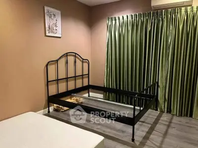 Spacious bedroom with metal bed frame and green curtains, perfect for customization.