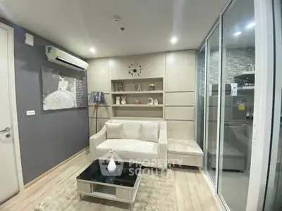 Modern living room with elegant decor and sliding glass doors leading to a stylish kitchen.