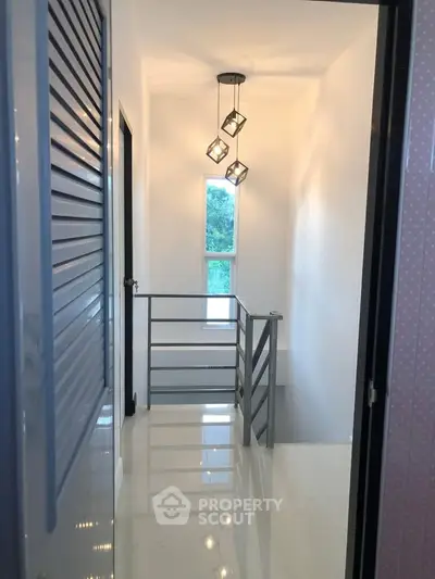 Modern hallway with sleek lighting and glossy flooring in a contemporary home.
