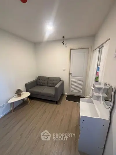 Cozy living room with modern gray sofa and stylish white furniture, perfect for relaxation.