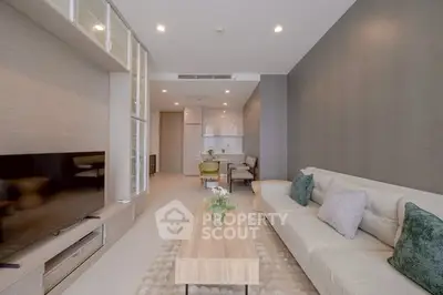 Modern living room with sleek furniture and neutral tones, featuring a cozy sofa and stylish decor.