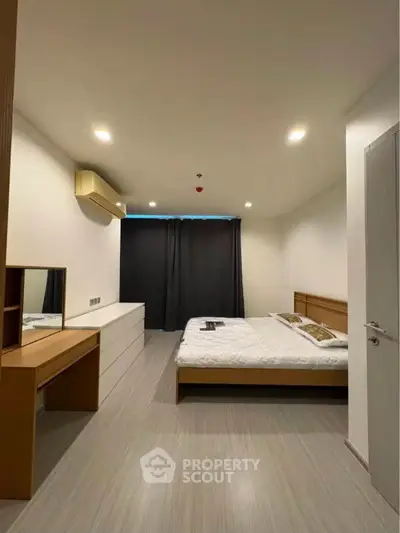 Spacious bedroom with modern furnishings and ambient lighting