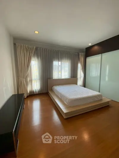 Spacious bedroom with modern design and large windows for natural light.