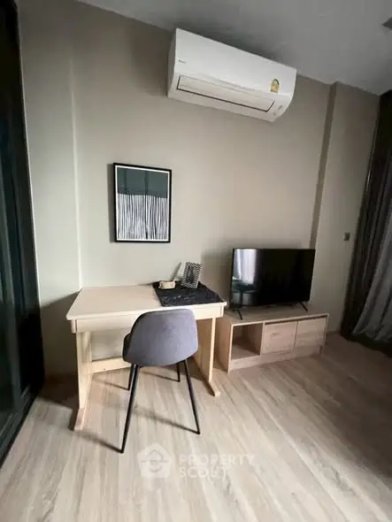 Modern study area with desk, chair, TV, and air conditioning in a stylish apartment.