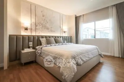 Luxurious bedroom with elegant decor and large window offering natural light.