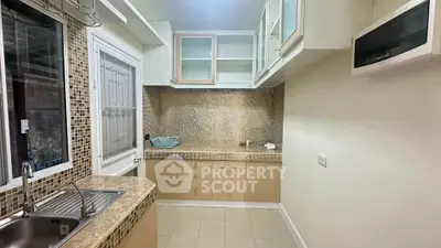 Modern kitchen with sleek cabinetry and mosaic backsplash in a cozy apartment.